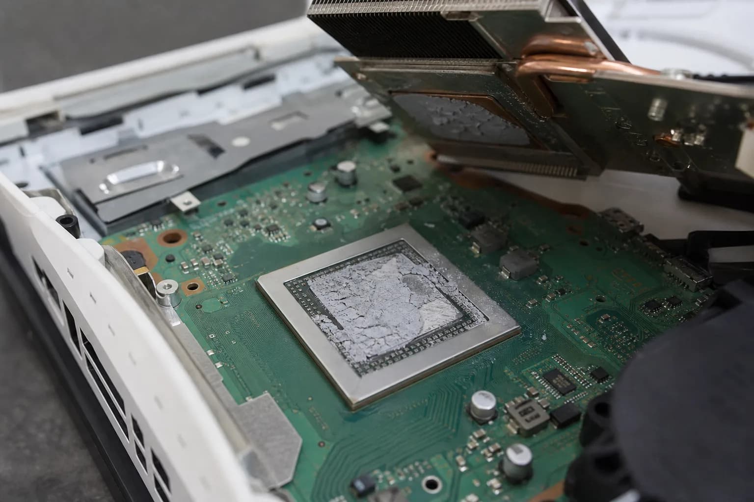 Vorher: PS5-Prozessor in Nahaufnahme mit ausgetrocknetem, rissig-krustigem Flüssigmetall